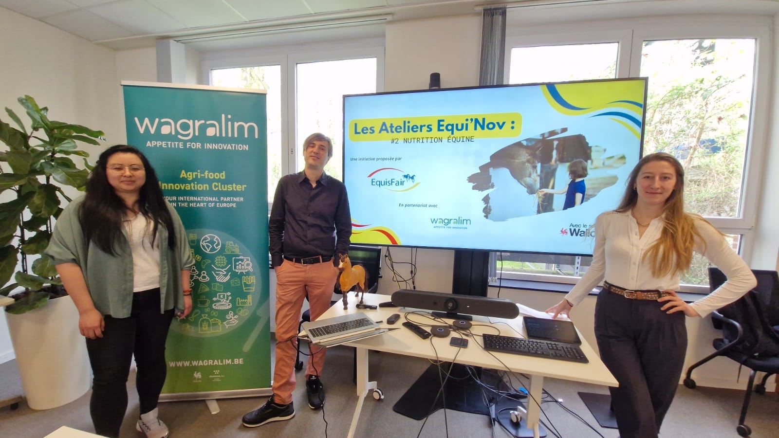 Trois personnes posent lors de l'atelier « Les Ateliers Equi'Nov #2 Nutrition équine » devant un écran de présentation EquisFair et Wagralim